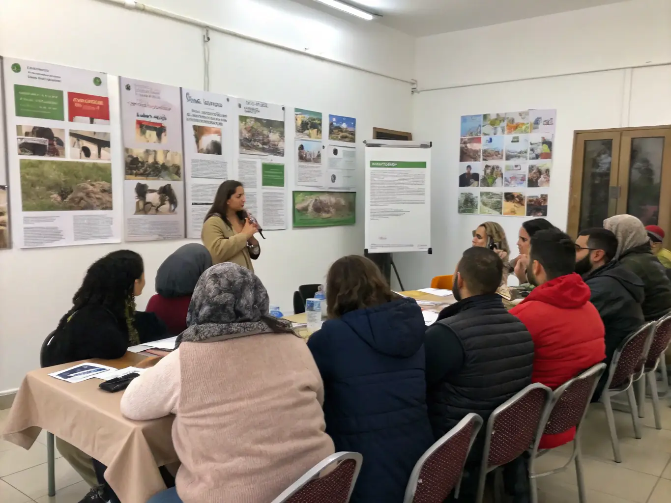 A group of community members attending a workshop on wildlife conservation, learning about local species and sustainable hunting practices.